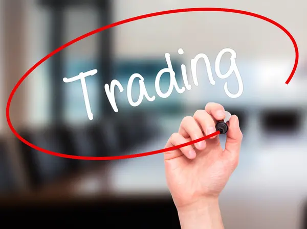 Man Hand writing Trading con marcador negro en pantalla visual — Foto de Stock
