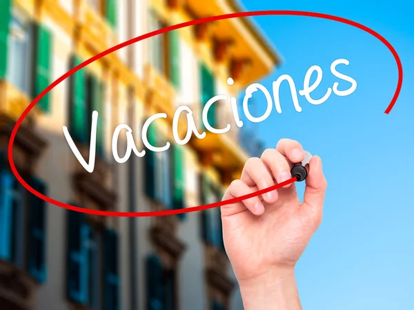 Man Hand writing Vacaciones (Férias em espanhol) com mar preto — Fotografia de Stock