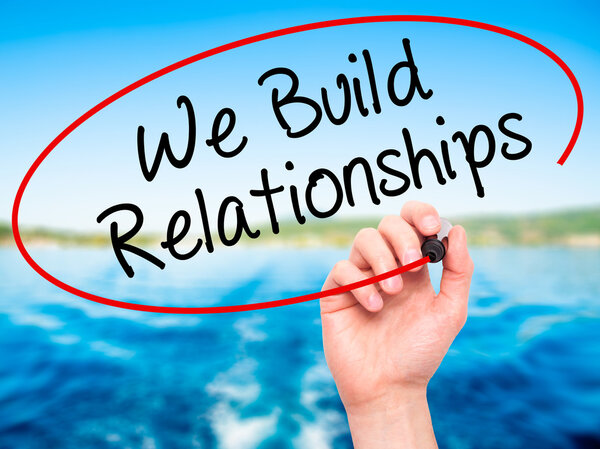 Рука человека пишет Мы строим отношения с черным маркером на Вис
