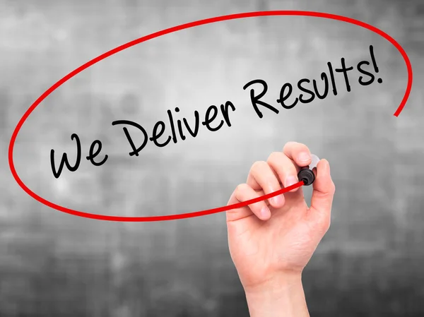 Man Hand writing We Deliver Results! with black marker on visual — Stock Photo, Image
