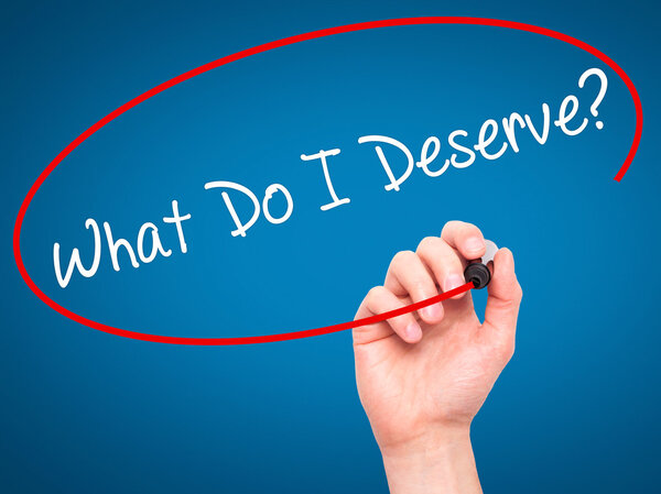 Мужская рука пишет Что я заслуживаю? с черным маркером на визуальной
 