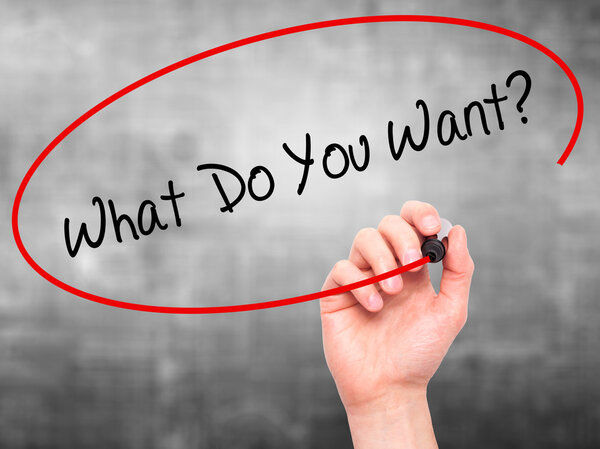 Мужская рука пишет "Чего ты хочешь?" с черным маркером на визуальной s
