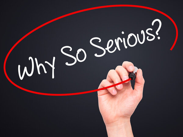 Мужская рука пишет "Почему так серьезно?" с черным маркером на визуальном скрабе
