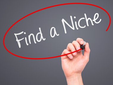 Man Hand writing Find a Niche with marker on transparent wipe bo