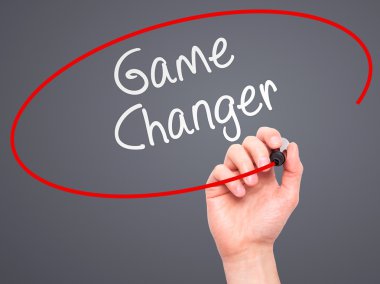Man Hand writing Game Changer with marker on transparent wipe bo
