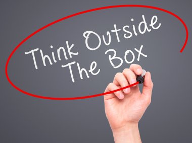 Man Hand writing Think Outside The Box with marker on transparen