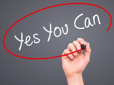 Man Hand writing Yes You Can with marker on transparent wipe boa