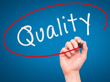 Man Hand writing Quality with marker on transparent wipe board