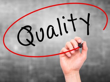 Man Hand writing Quality with marker on transparent wipe board