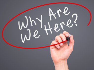Man Hand writing Why Are We Here black marker on visual screen