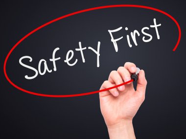 Man Hand writing Safety First with marker on transparent wipe bo