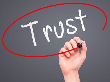 Man Hand writing Trust black marker on visual screen