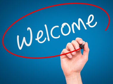 Man Hand writing Welcome with marker on transparent wipe board
