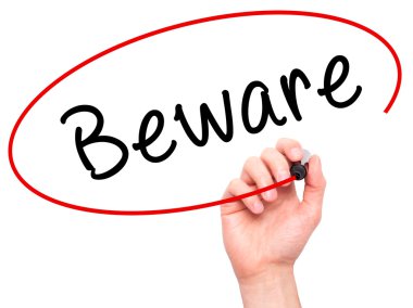 Man Hand writing Beware  with marker on transparent wipe board