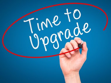 Man Hand writing Time to Upgrade with marker on transparent wipe