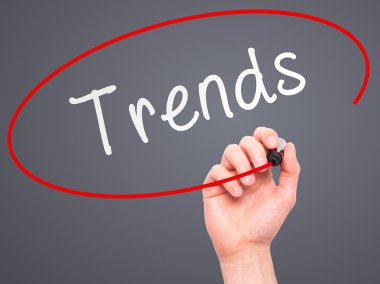 Man Hand writing Trends with marker on transparent wipe board