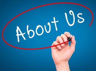 Man Hand writing About Us with marker on transparent wipe board