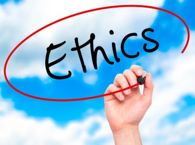 Man hand writing Ethics on visual screen