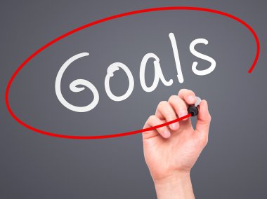 Man hand writing Goals on visual screen