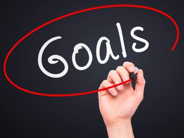 Man hand writing Goals on visual screen