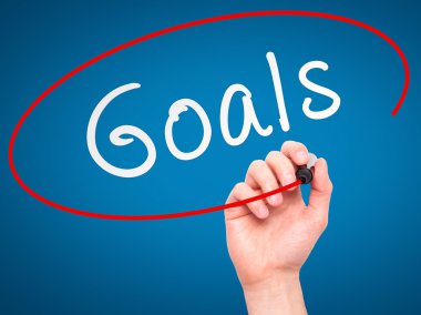 Man hand writing Goals on visual screen
