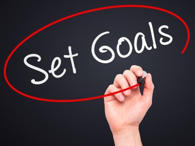 Man hand writing Set Goals on visual screen