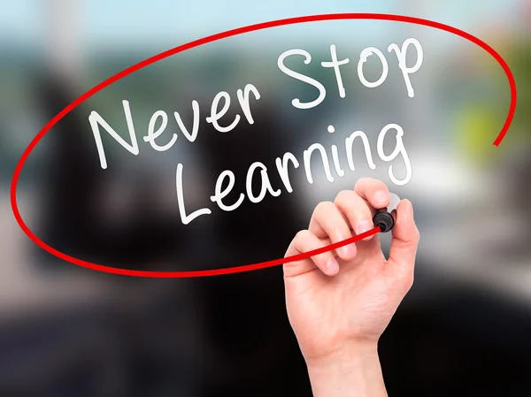 Man hand writing Never Stop Learning on visual screen — Stok fotoğraf