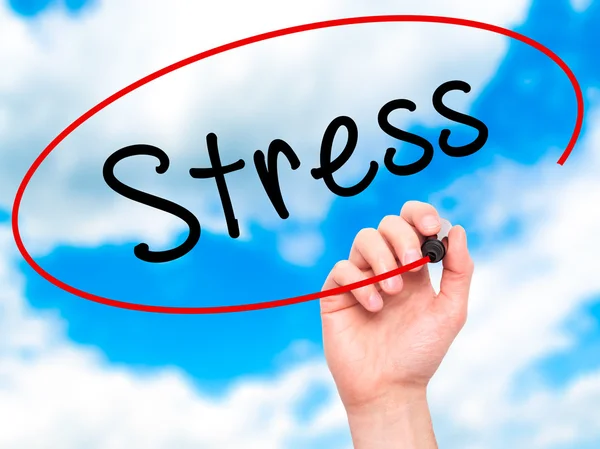 Man Hand writing Stress with marker on transparent wipe board