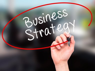 Man Hand writing Business Strategy with black marker on visual s