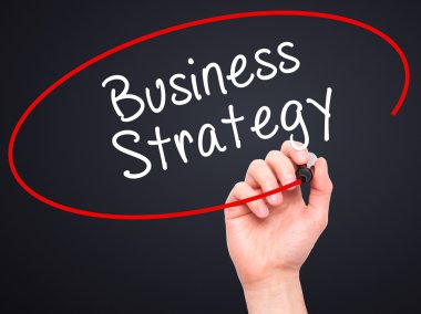 Man Hand writing Business Strategy with black marker on visual s