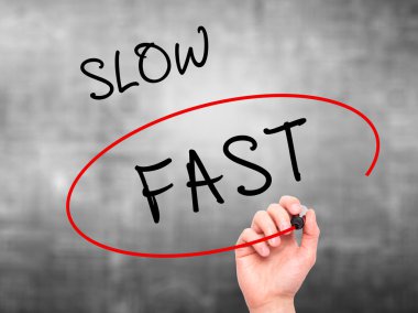 Man Hand writing and Choosing Fast instead of Slow with black ma