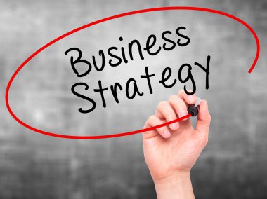 Man Hand writing Business Strategy with black marker on visual s