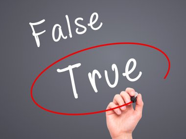 Man Hand writing an choosing True instead of False with black ma