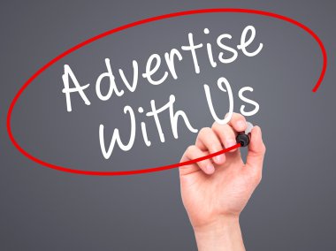 Man Hand writing Advertise With Us  with black marker on visual 