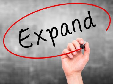 Man Hand writing Expand with marker on transparent wipe board