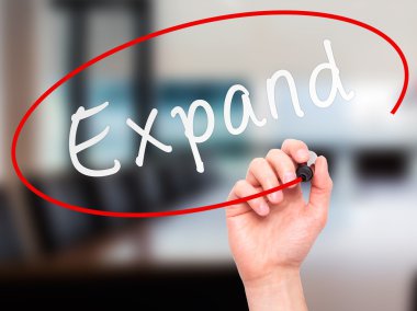 Man Hand writing Expand with marker on transparent wipe board