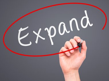 Man Hand writing Expand with marker on transparent wipe board