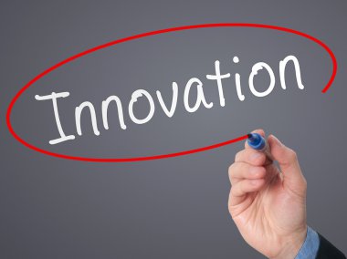  Businessman hand writing innovation in the air