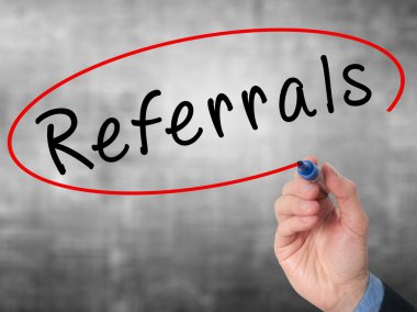 Man Hand writing Referrals with marker on virtual screen