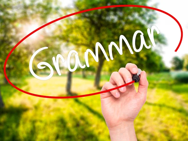 Man Hand skriver grammatik med svart markering på visuella skärm — Stockfoto