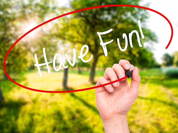 Man Hand writing Have Fun! with black marker on visual screen