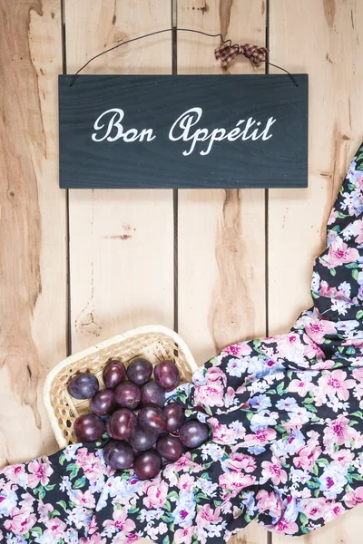 Ripe plums on the wooden background