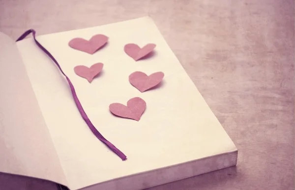 Paper hearts on a book — Stock Photo, Image