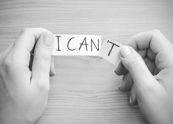Hands tear a paper with text "I can 't " — стоковое фото