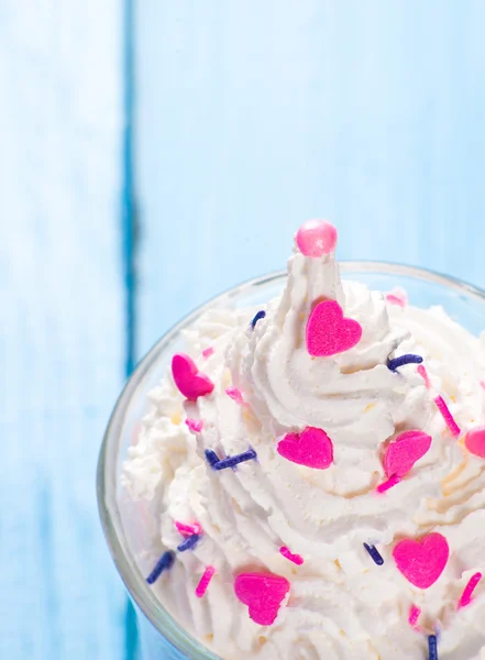 Top of whipped cream with sweet decors on blue wood background — Stock Photo, Image