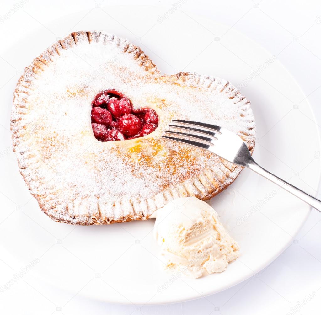 Heart shaped cherry pie with vanilla ice cream on white background