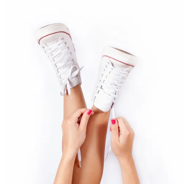 Sneakers sulle gambe delle donne — Foto Stock