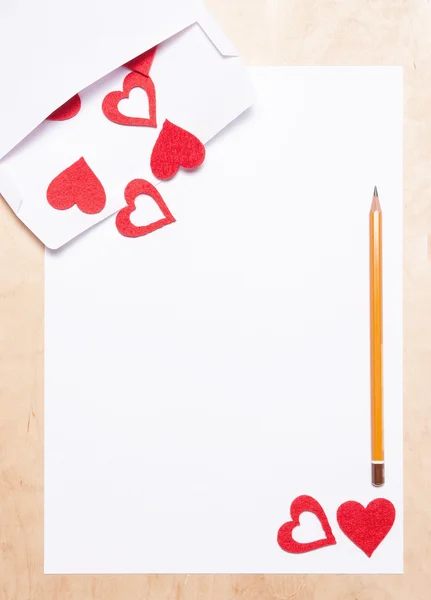 Серця в конверті, папері та олівці — стокове фото