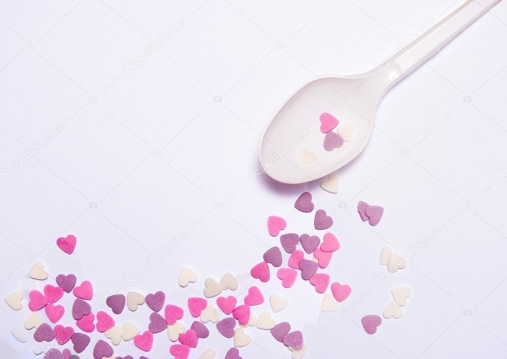 Heart candies on white spoon