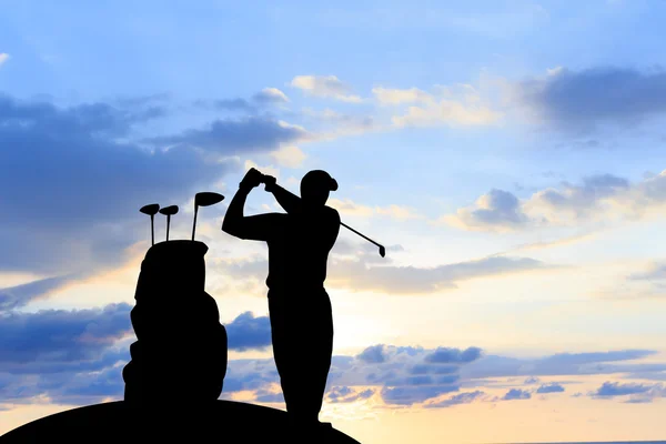 Silhouet golfspeler mooie hemel verlicht zonsondergang achtergrond. — Stockfoto